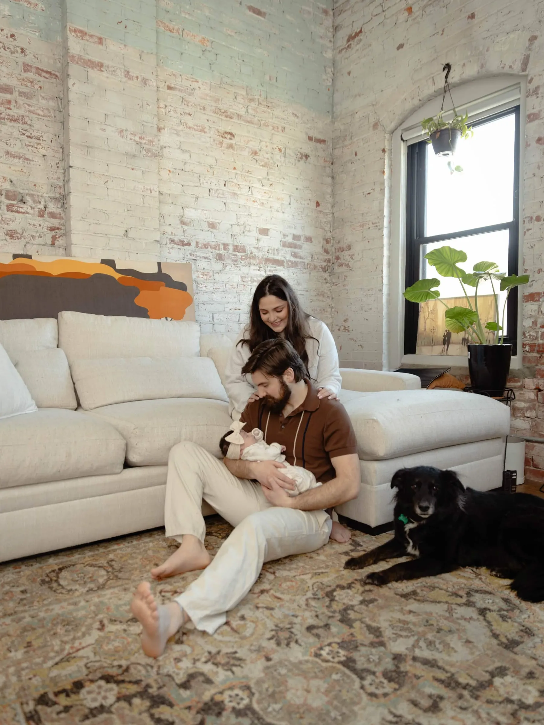 Ashley at home with her family and dogs on a bright living room couch.